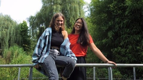 Mentorin Angelique und Emma stehen gemeinsam auf einer Brücke