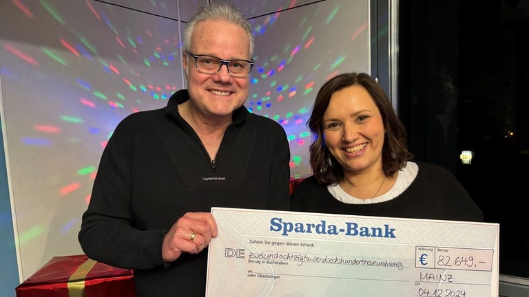 SWR1 Moderatorin Steffi Stronczyk und SWR1 Moderator Michael Lueg mit der Spendensumme zugunsten von Herzenssache