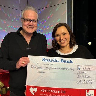 SWR1 Moderatorin Steffi Stronczyk und SWR1 Moderator Michael Lueg mit der Spendensumme zugunsten von Herzenssache