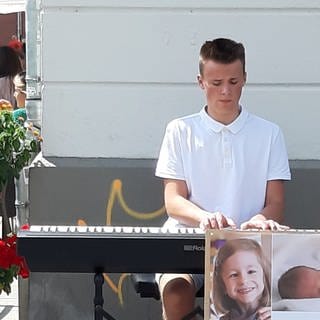Laurin spielt in der Innenstadt Klavier um Spenden zu sammeln. (Foto: Herzenssache e.V.)