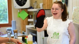 Mädchen mit Downsyndrom hält Back-Handschuh