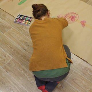 Mädchen malt auf dem Boden 