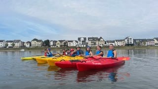 Kinder in Kajaks auf dem Wasser