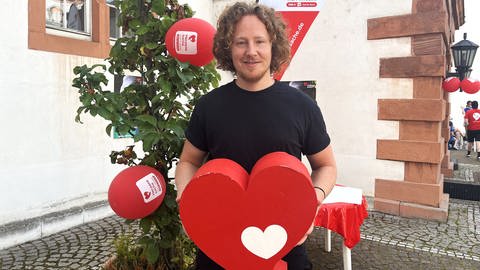 Michael Schulte hält ein Herzenssache-Herz in seiner Hand